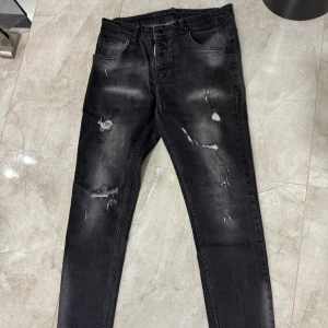 Dsquared2 jeans - Snygga svarta jeans med slitningar från dsquared2! Har använt jeansen ett tag så nu är det dags att sälja de! Sitter relativt bra på mig som är 1,83 och väger 71kg! Hör av er vid minsta fundering✔️