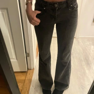 Svarta bootcut jeans från Ginatricot  - Snygga svarta bootcut jeans från Perfect Jeans. De har en klassisk femficksdesign med knappar och dragkedja framtill. Perfekta för en stilren look.