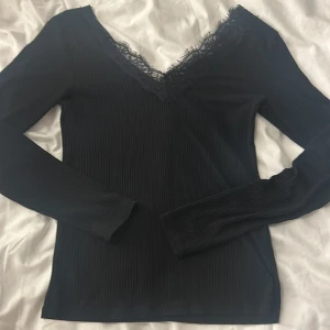 Svart ribbad topp från New yorker 💕 - Snygg svart ribbad topp från New yorker med spetsdetaljer. Står storlek M men passar som S💕 Är nästan som intimissimi tröjan. Långärmad och tillverkad i ett mjukt material💕