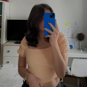 Persikofärgad ribbad topp - Säljer en söt persikofärgad ribbad topp med puffiga korta ärmar! Perfekt till sommaren❣️Använd ett fåtal gånger. Strl S men passar även XS