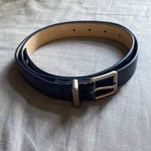 Marinblått mocka bälte - Snyggt marinblått mocka bälte med ett stilrent silverfärgat spänne. Perfekt för att ge en färgklick till din outfit. Skärpet har flera hål för justerbar passform. (Helt oanvänd) Det är 105cm långt, skriv vid minsta fråga eller fundering💯👍