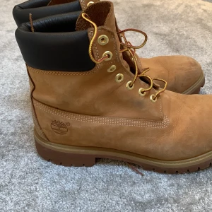 Bruna kängor från Timberland - Säljer ett par klassiska bruna kängor från Timberland med snörning och vadderad krage. Perfekta för höst och vinter med robust design och slitstarkt material.storlek 45 men passar 46,5. Ny pris 1700kr mitt pris 999kr