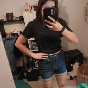 Blå jeansshorts - Snygga blå jeansshorts med normal passform och klassisk design. Perfekta för sommardagar och avslappnade tillfällen. De har en bekväm midwaist och är ett måste i garderoben!