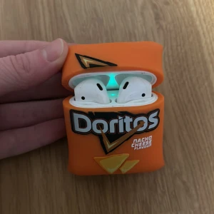 AirPods-fodral med Doritos-design - AirPods-fodral i form av en Doritos Nacho Cheese-påse. Fodralet är orange med Doritos-logga och ostchipsmotiv. *Bara fodralet som säljs och inte AirPodsen💗
