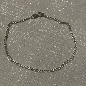 Silverfärgat armband med kedjedesign - Elegant silverfärgat armband med en klassisk kedjedesign. Perfekt för att lägga till en subtil touch av stil till din outfit. Armbandet har en säker låsning som gör det enkelt att ta på och av. 21cm lång 