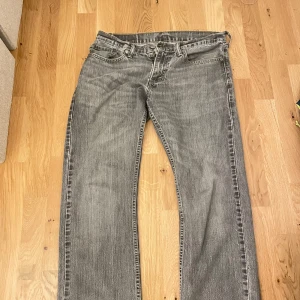 Grå Levis 514 jeans - Säljer ett par grå Levis 514 jeans med klassisk femficksdesign och dragkedja. De har en straight passform och är perfekta för en avslappnad stil. Märkeslappen sitter på baksidan av midjan.