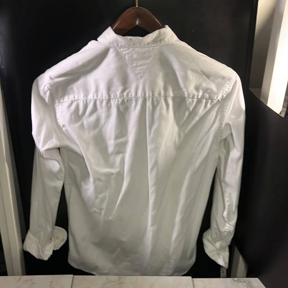 Klassisk vit skjorta från Tommy Hilfiger med knappar och långärmad design. Perfekt för en stilren look. Tillverkad i ett bekvämt material som passar till många tillfällen. Hör av er vid minsta fundering🙌. Paidat.