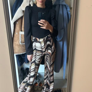 Mönstrade byxor med vida ben - Snygga byxor med ett unikt mönster i brunt, beige och svart. 