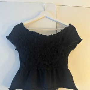 Svart offshoulder topp - Snygg svart offshoulder topp med smockdetaljer och volangkant från Gina Tricot!! Storlek: xs💗🫶🏼