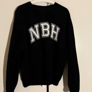 Neighborhood sweater - Säljer en svart tröja från Neighborhood med bokstäverna 'NBH' i vitt på framsidan. Tröjan har en normal passform och är tillverkad i 100% bomull. 