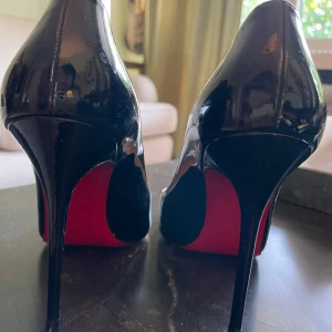 Svarta klackskor från Christian Louboutin - Snygga svarta klackskor från Christian Louboutin med den ikoniska röda sulan. Skorna har en elegant design med spetsig tå och hög klack, perfekt för att ge en stilfull touch till din outfit.