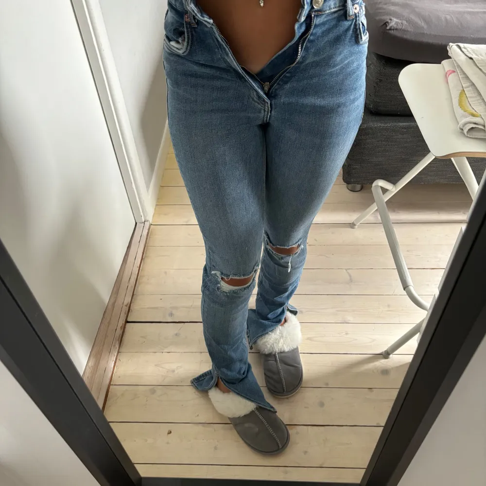 Säljer ett par snygga blå jeans från Zara. De är högmidjade och har en tight passform med slitna detaljer på knäna. Perfekta för en casual look eller att klä upp med en snygg topp. Superbekväma och stilrena!. Jeans & Byxor.