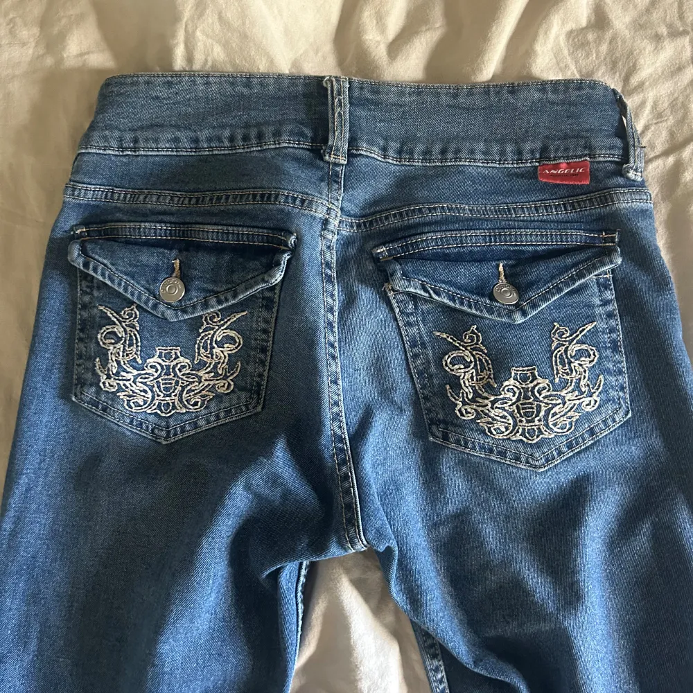 Säljer ett par snygga blå jeans med broderade detaljer på bakfickorna. De har är bootucut och lågmidjade. Använda Max 3 gånger så i nytt skick. . Jeans & Byxor.