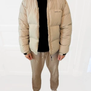 Pufferjacka från Axel Arigato - Snygg Pufferjacka från Axel Arigato i beige färg.