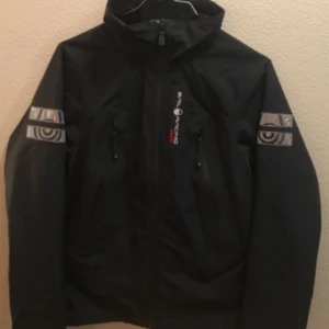 Sail Racing Jacka Goretex XS - En svart Sail Racing Goretex jacka i st XS. Nyskick. Xs men funkar till S. Den funkar unisex också.  Dam model men funkar till ungdomar också utan att det syns någon skillnad. Funkar unisex och ungdomar 158-170. 