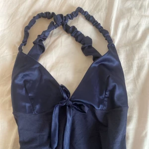 Klänning/linne - Fin söt liten klänning med bar rygg. Står storlek L men skulle mer säga att det är S/M. Längd från rosetten 50 cm