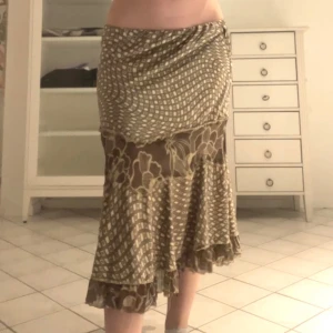 Brun mönstrad kjol  - Så snygg kjol med mixade mönster, i bra skick. Midja 80 cm längd 65 cm
