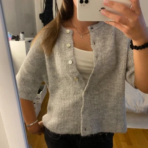 Kortärmad stickad  - Säljer min helt nya stickad kofta från Gina Tricot. Prislappen är kvar och är endast testad! Nypris 359kr🫶🏼💞 Tryck inte köp nu!