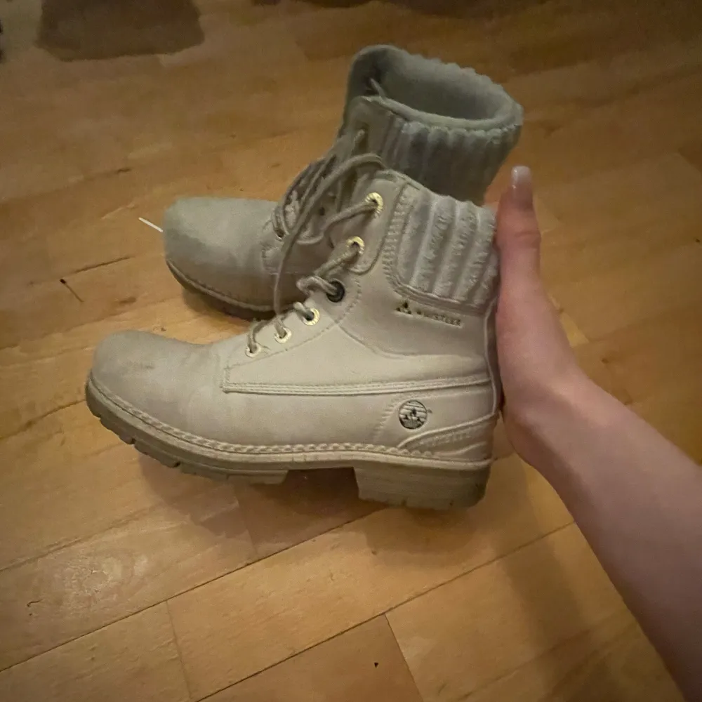 Säljer ett par snygga beige boots från Whistler i bra skick. De har en mysig stickad kant upptill och snörning framtill. Perfekta för höst och vinter med sin robusta design och bekväma passform.. Skor.