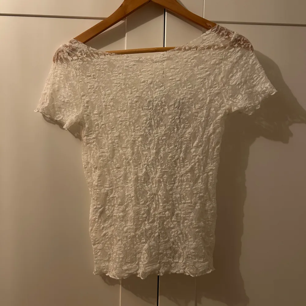 Säljer en superfin vit spetsblus i mycket bra skick. Den är kortärmad och har en elegant offshoulder-design. Perfekt för sommarens alla fester eller en mysig vårdag. Materialet är lätt och luftigt, vilket gör den bekväm att bära hela dagen. Kragen har jag själv klippt så att den är i offshoulder look. Köpt utomlands flera år sen aldrig kommit till användning. Mycket vitare färg än i bilden!!!. Toppar.