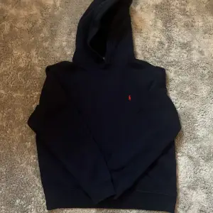 Säljer en mörkblå hoodie från Polo Ralph Lauren i storlek barn XL. Perfekt för höst och vinter, och den är superbekväm att ha på sig