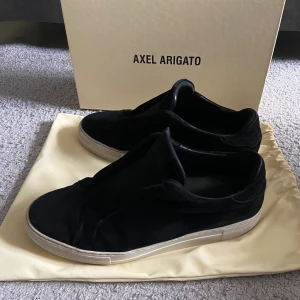 Axel Arigato skor svarta - Tjena, säljer ett par stilrena svarta skor från Axel Arigato. De är i mycket bra skick och kommer med originalförpackning och dustbag.  Priset är inte hugget i sten och kan diskuteras vid snabb och smidig affär! Har du fler funderingar är det bara och höra av sig:)