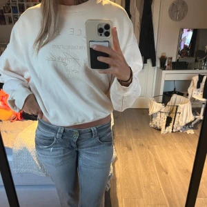 Beige sweatshirt från Bik Bok - Säljer en superfin vit sweatshirt från Bik Bok i storlek L. Den har en cool text på framsidan och är perfekt för en avslappnad look. Tröjan är i bra skick och passar perfekt till jeans för en casual stil. Perfekt för höst och vår!