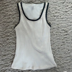 Super gullig topp/linne, med detalj - Ett super gulligt vitt linne, men broderade detaljer längs med kanten. Är i storlek S men skulle säga att det passar XXS/XS. Helt oanvänt.