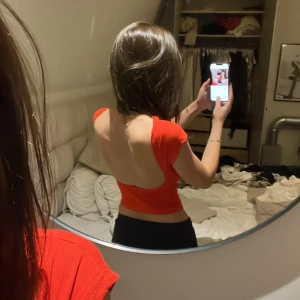 Röd topp med öppen rygg - Säljer en snygg röd topp med öppen rygg. Passar perfekt till både jeans och kjol! Använd någon gång men inget som syns på tröjan🥰