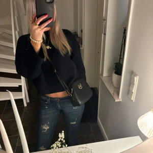 Svart väska - Snygg svart axelväska i skinn med gulddetaljer och Michael Kors logotyp framtill. Perfekt för både vardag och fest. Väskan har en justerbar rem och en praktisk dragkedja för säker förvaring. En stilren accessoar som passar till alla outfits särskilt nu till höst och vintern💕(obs inte äkta)