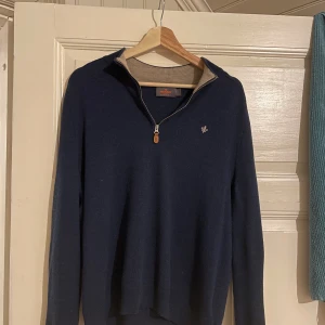 Mörkblå tröja med dragkedja från Morris - Säljer en stilren mörkblå half zip tröja från Morris. Tröjan är i 9/10 skick, inga hål eller fläckar eller liknande. Väldigt snygg och i bra skick, perfekt för höst, vår och vinter. Storleken är Large men sitter mer som Medium då den krympt något i tvätten.