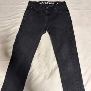 Säljer ett par svarta jeans från Dickies i storlek 31x32. De är i bra skick och har en klassisk femficksdesign. Perfekta för både vardag och fest. Passformen är normal och de är tillverkade i ett slitstarkt material.