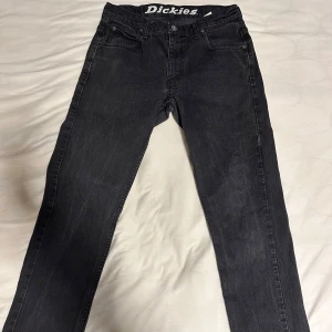 Svarta Dickies jeans W31 L32 - Säljer ett par svarta jeans från Dickies i storlek 31x32. De är i bra skick och har en klassisk femficksdesign. Perfekta för både vardag och fest. Passformen är normal och de är tillverkade i ett slitstarkt material.
