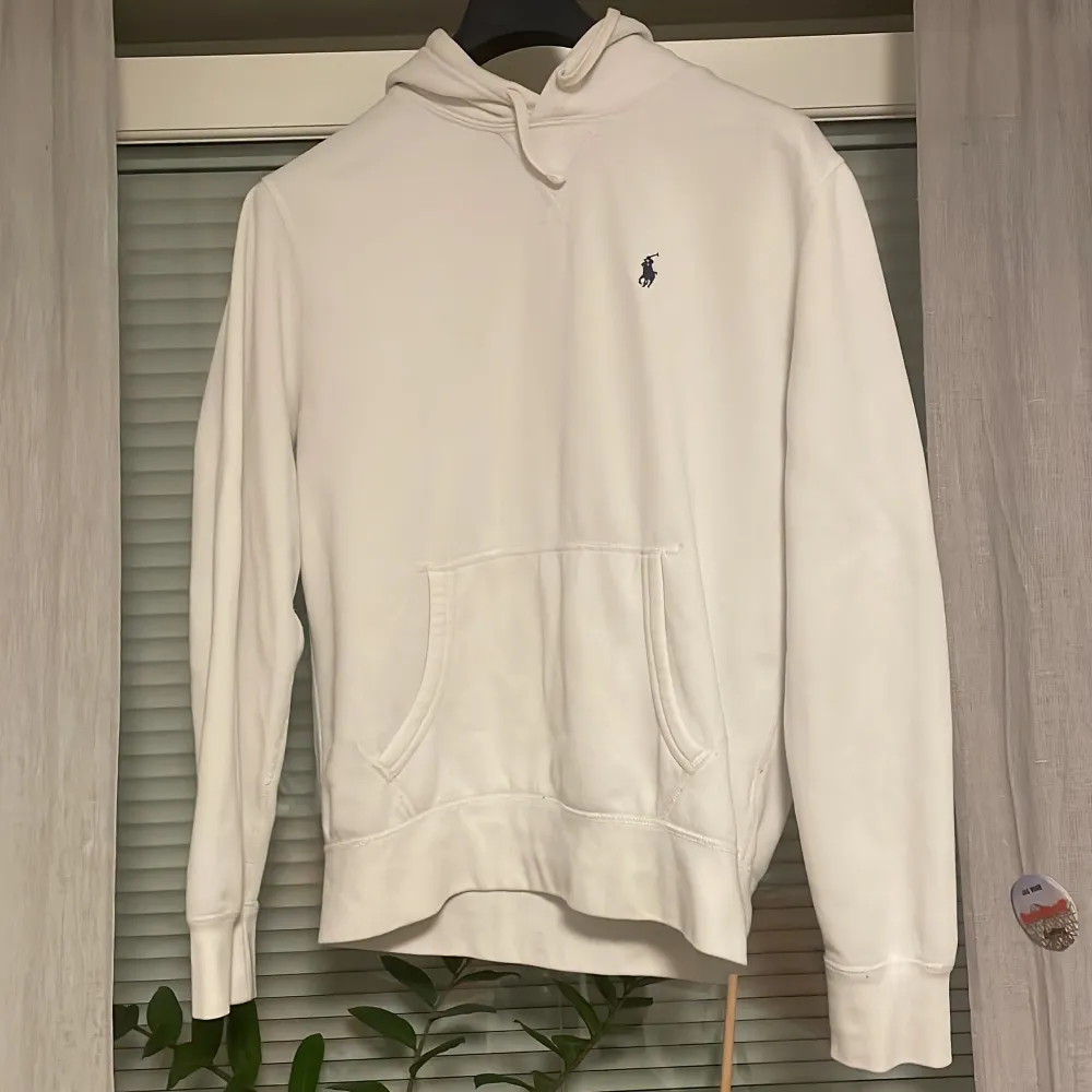 Säljer en stilren vit hoodie från Ralph Lauren i mycket bra skick med nypris 1800. Den har en klassisk passform med långa ärmar och en praktisk magficka. Perfekt för både vardag och avslappnade tillfällen. Den ikoniska loggan är broderad på bröstet. Passar perfekt till höst och vår!. Tröjor & Koftor.