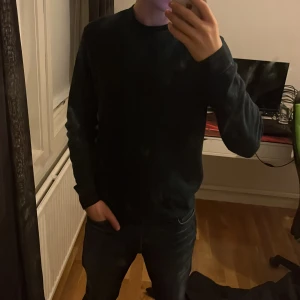 Mörkblå tröja från Boss - Säljer en stilren mörkblå/grön tröja från Boss i mycket bra skick. Tröjan är långärmad och har en normal passform, perfekt för både höst och vinter. Den är gjord i ett mjukt material som känns skönt mot huden. Passar lika bra till vardags som till lite finare tillfällen.
