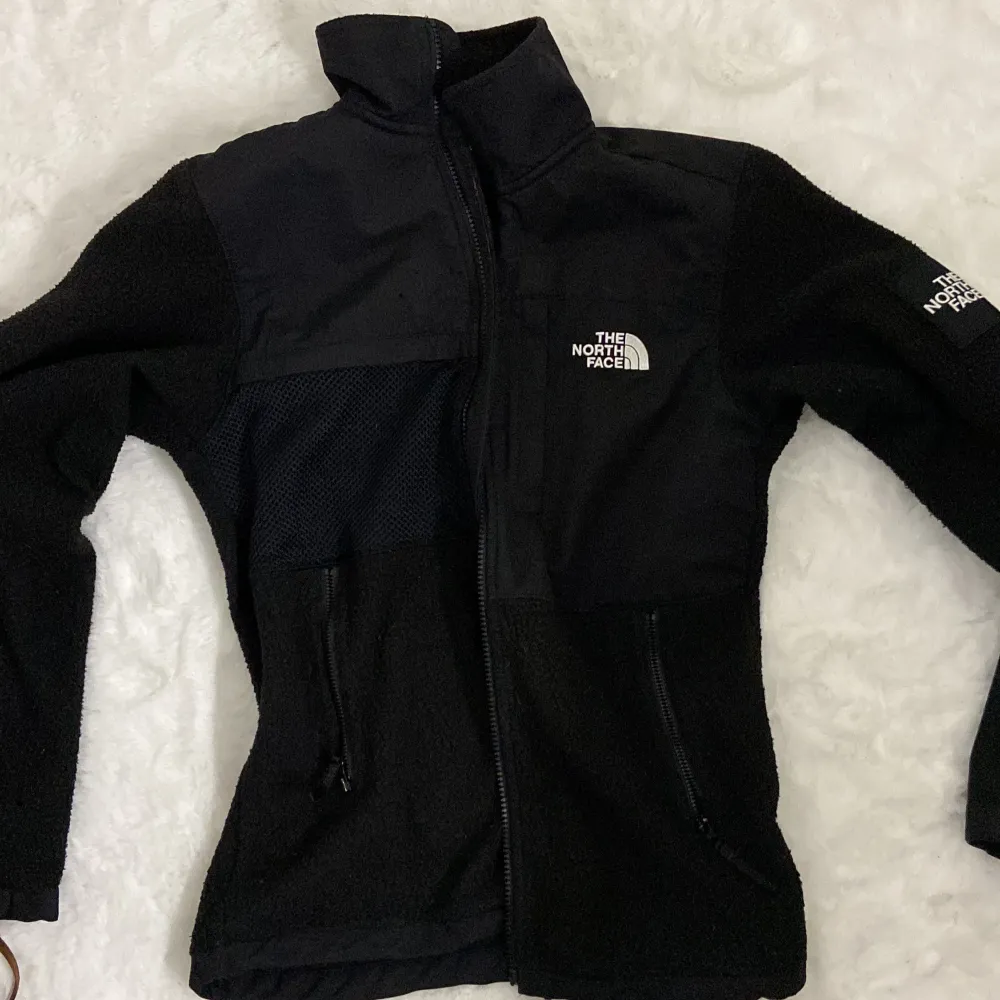 Säljer en svart fleecejacka från The North Face i mycket bra skick. Jackan har en dragkedja framtill och är långärmad. Perfekt för kyliga höst- och vinterdagar. Den är både stilren och funktionell, med en normal passform.. Jackor.