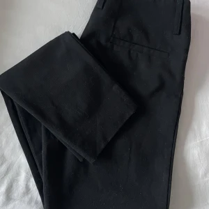 Svarta kostymbyxor från Filippa K - Snygga svarta kostymbyxor från Filippa K i storlek S. De har en klassisk design med en rak passform och är perfekta för både jobb och fest. Byxorna är tillverkade i ett bekvämt material som ger en stilren look. Perfekta för höst och vinter!