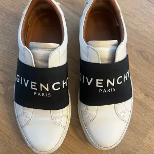 Säljer ett par stilrena vita sneakers från Givenchy i bra skick. Skorna är tillverkade i skinn och har en klassisk design med rund tå och låg profil. Perfekta för både vardag och fest! Använt ett fåtal gånger, säljer pga nya skor. Upplever dem som lite stora i storleken, har vanligtvis 38 men dessa sitter perfekt. Köpa i Milano. Skokartongen, dustbag och kvitto medföljer! Har även påsen kvar om så önskas. Nypris ligger runt 6000:- 