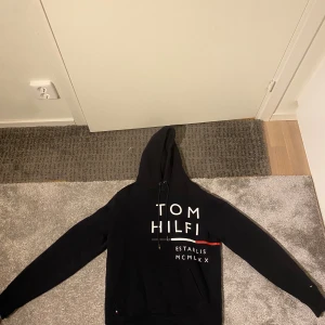 Tommy Hilfiger Hoodie mörkblå - Jag säljer en mörkblå Tommy Hilfiger Hoodie i storleken Small.