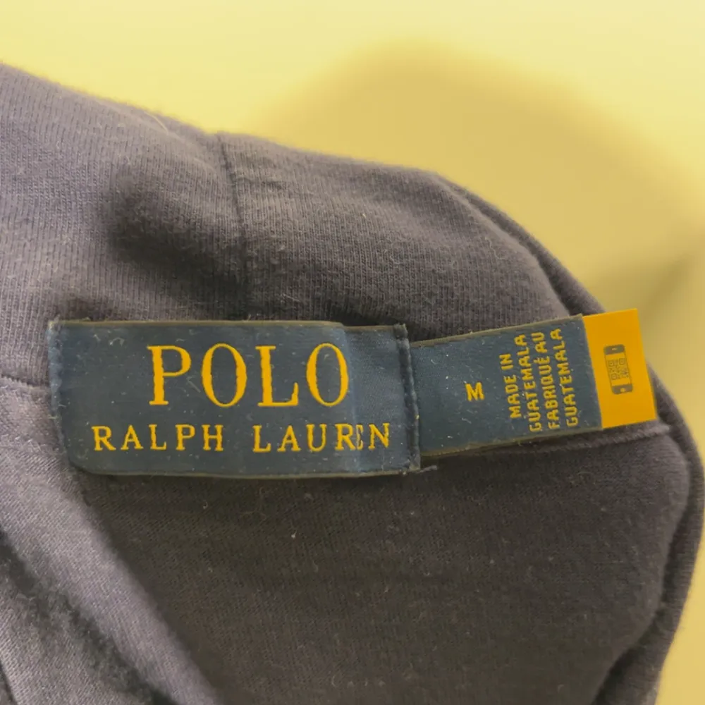 Säljer en snygg mörkblå hoodie från Polo Ralph Lauren med en cool björntryck på framsidan. Perfekt för en avslappnad stil med långa ärmar och en skön passform. Passar både till vardags och chillkvällar. 🐻💙. Tröjor & Koftor.