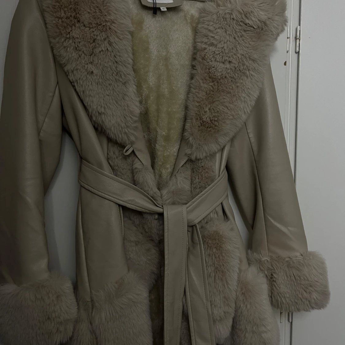 Beige kappa med pälsdetaljer