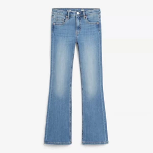 Blå bootcut jeans - Snygga blå bootcut jeans med en klassisk femficksdesign. De har en dragkedja och knapp framtill. Perfekta för en avslappnad stil med en touch av retro. Storlek 152 men passar xxs. Ett litet sträck på ena låret men annars bra skick!