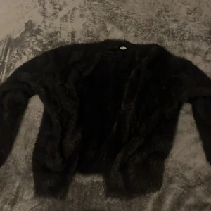 Svart pälskofta - Säljer en elegant svart pälsjacka i storlek XS. Jackan har en mjuk och lyxig känsla, perfekt för att hålla dig varm och stilren under kyliga dagar. Den har långa ärmar och en klassisk design som passar till många olika outfits.