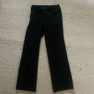 Svarta byxor - Snygga svarta kostymbyxor med en klassisk design. De har en rak passform och är perfekta för en stilren look. Passar till många olika tillfällen och kan enkelt matchas med olika toppar.