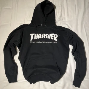 Thrasher hoodie - Säljer en svart hoodie från Thrasher med deras ikoniska logga i vitt på framsidan.