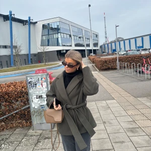 Grön kappa  - Snygg grön kappa som ger en stilren look. Perfekt för höst samt vår. Passar bra till både vardag och mer uppklädda tillfällen. Nypris 699 kr, mitt pris 350 kr. Väldigt bra skick, tvättas såklart innan den postas. 