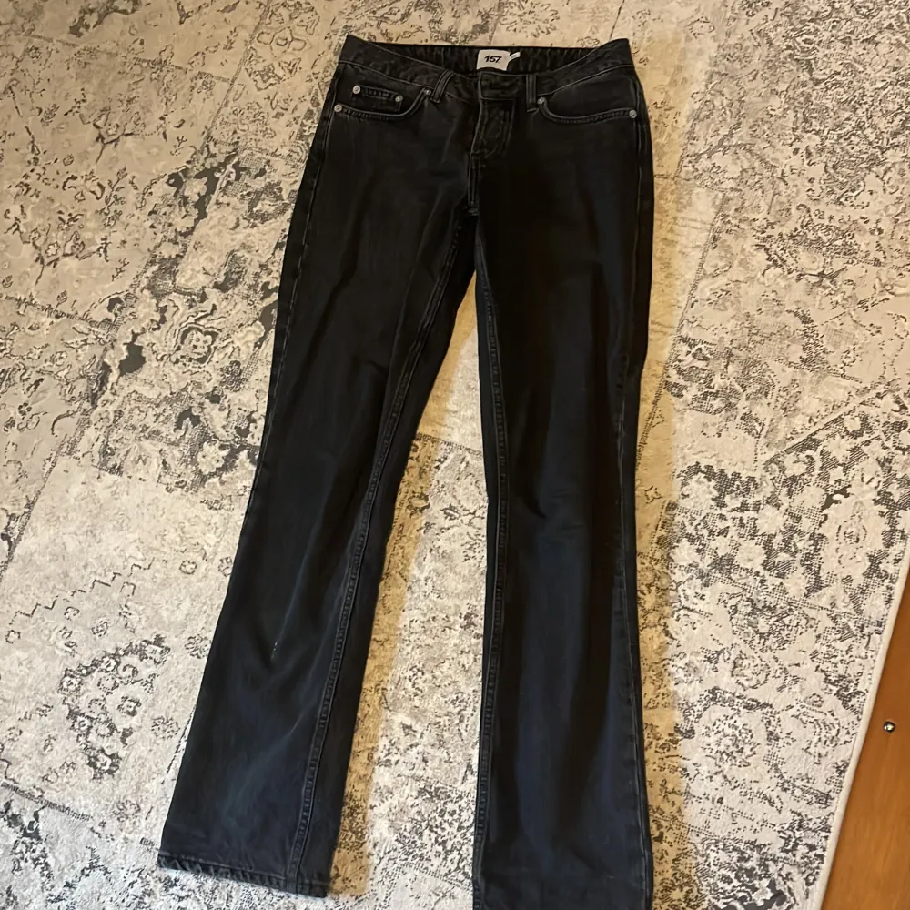 Snygga svarta jeans med bootcut-stil. De har en klassisk femficksdesign och en bekväm passform. Perfekta för en stilren look.. Farkut & Housut.