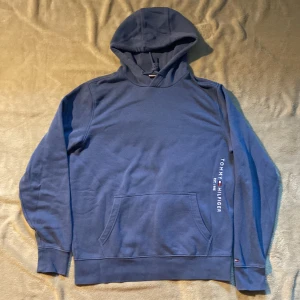 Blå hoodie från Tommy Hilfiger - Säljer denna blåa hoodie från Tommy Hilfiger! Använd ett fåtal gånger men helt utan defekter!Priset är diskutabelt.  :)