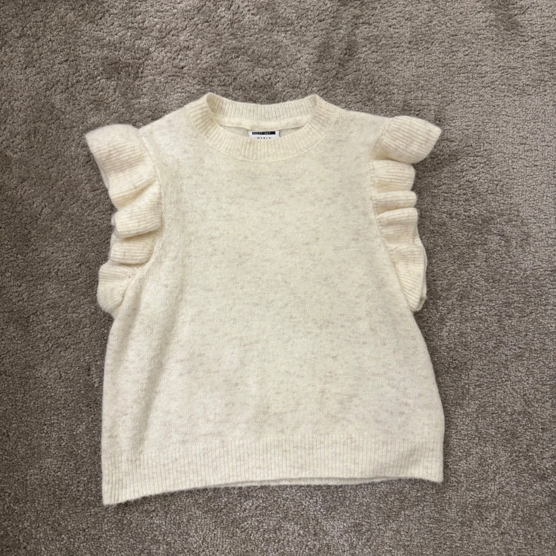 Vit stickad topp med volangdetaljer