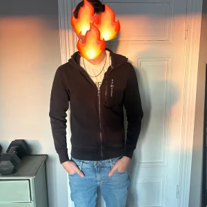 Sail racing - Säljer en stilren sail racing hoodie med dragkedja framtill. Den har långa ärmar och en bekväm passform, perfekt för vardagsbruk. Hoodien har en liten logga på bröstet och en justerbar huva.